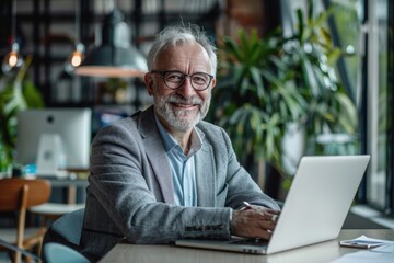 Wall Mural - A person sits at a table with a laptop, working or studying