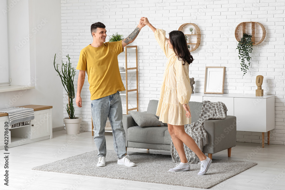 Beautiful young couple dancing at home