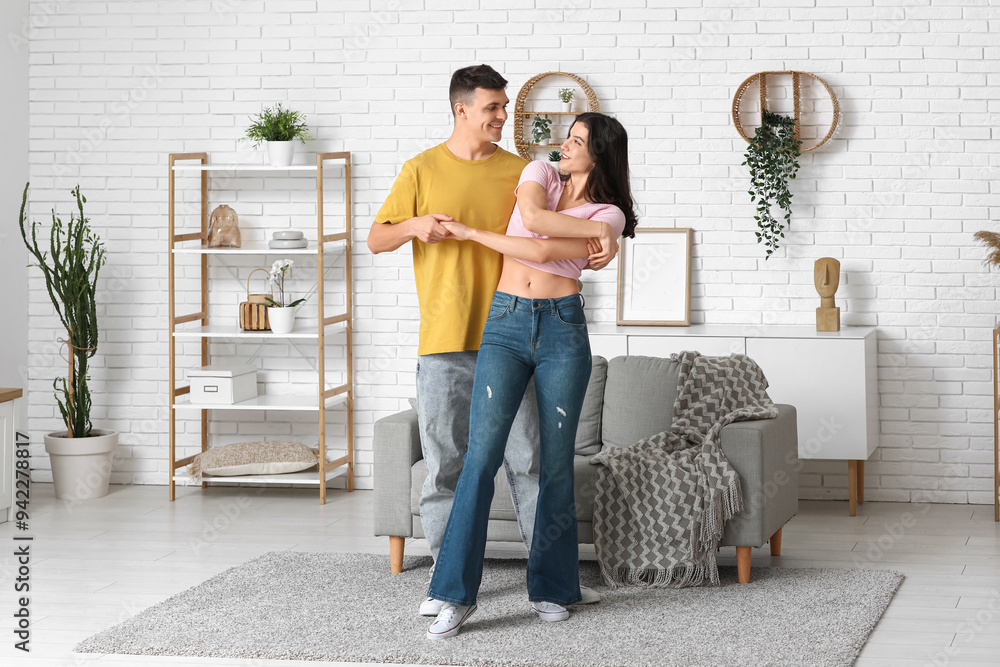 Happy young couple dancing at home