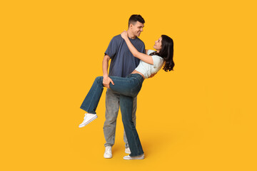 Poster - Beautiful young couple dancing on yellow background