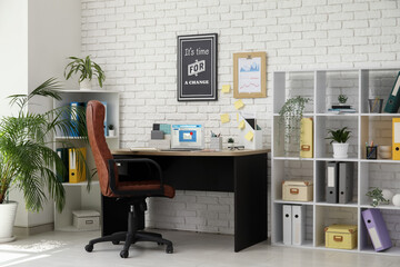 Poster - Interior of office with workplace, brown armchair, modern laptop and shelving unit