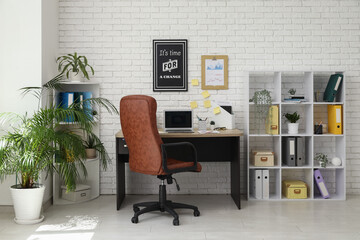 Poster - Interior of office with workplace, brown armchair, modern laptop and shelving unit