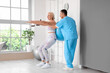 © Pixel-Shot - Male physiotherapist and mature woman training with fitball in rehabilitation center