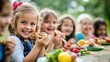 © starush - A group of children eating food at a picnic table, AI