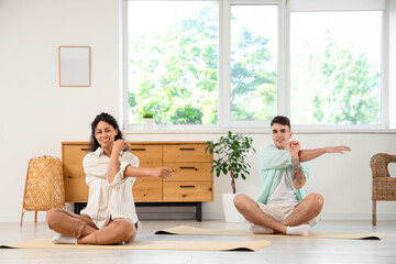 Young couple practicing pilates together at home