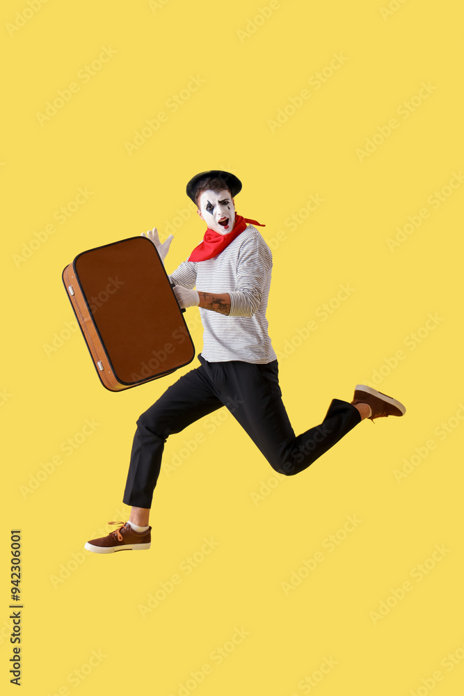 Jumping male pantomimist with bag on yellow background