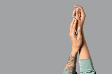 Wall Mural - Female hands with beautiful manicure against grey background, closeup