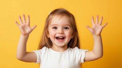 A young girl is smiling and waving her hands in the air