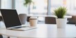 © 为轩 张 - Blurred Modern Office Interior with Laptop and Coffee Cup on White Table, Minimalist Home Workspace for Online Education or Remote Business Concepts