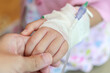 © Kwangmoozaa - Mother holding child hand with saline IV solution in hospital