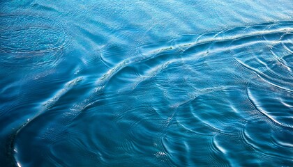 Blue water with ripples on the surface. Defocus blurred transparent blue colored clear calm water surface texture with splashes and bubbles. Water waves with shining pattern texture background.