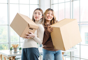 Wall Mural - Portrait two roommates happy young Asian female moving packing things in box into new apartment, carry cardboard boxes, Concept teenage or friends, Real estate property buying, relocation, new home