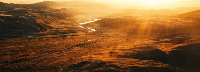 Wall Mural - Aerial View of a River Winding Through Golden Hills at Sunset