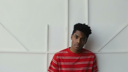 Wall Mural - teen stunning black hair american man with red shirt model portrait standing straight on a white wall for ad concept space for text