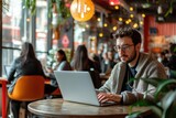 Digital nomad working from a laptop in a vibrant co-working space, with a diverse group of people in the background