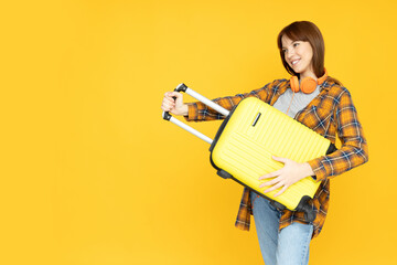 Wall Mural - Attractive young girl with a suitcase in her hands