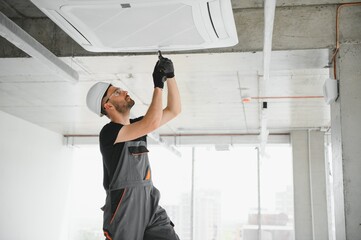 Wall Mural - technician cleans air conditioner system in a modern apartment