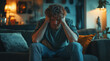 © James - A man sitting on the couch with his head in hands, looking distressed and emotional, showing signs of anxiety or depression. The concept of emotional pain and suffering due to life events.