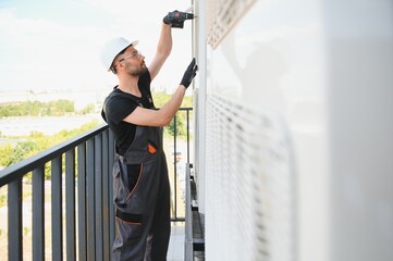 Wall Mural - Technician man install new air conditioner, Repairman service for repair and maintenance of air conditioners