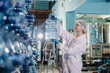 © Quality Stock Arts - Women worker in drinking water factory working check cleanliness of water bottle gallon storage warehouse.