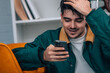 © carballo - young man at home looking at his mobile phone