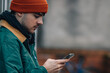 © carballo - portrait of young man with hat and warm clothes looking at mobile phone