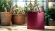 © TAHIYA - Red shopping bag on a table, with natural light and greenery in the background
