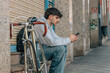© carballo - urban cyclist sitting on the street with mobile phone