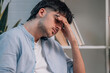 © carballo - young man on the sofa at home with his hand on his head in pain or stress