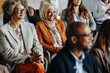 © Jacob Lund - Diverse group of professionals attending a business conference with a Muslim woman smiling in the audience