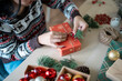 © Charlie's - Woman in knitted sweater wrapping christmas presents with eco paper girl packing christmas gifts Xmas holiday concept