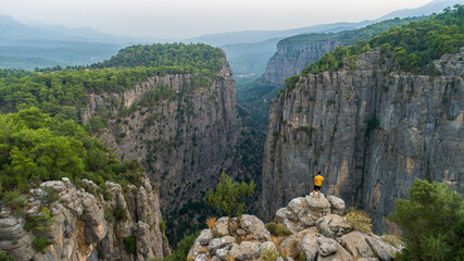 Canvas Print - A man climbing Tazi Canyon and watching the view. A man enjoying the magnificent harmony of trees and mountains in the canyon.