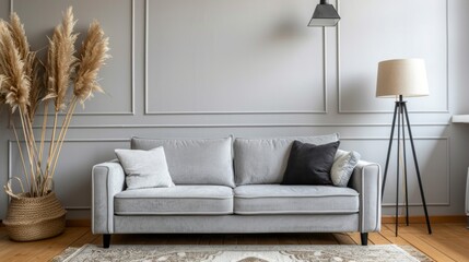 Wall Mural - A gray couch sits in a living room with a lamp and a potted plant