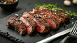 © Lukita - Sliced medium rare steak with herbs and spice in black plate food photography concept.