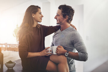 Canvas Print - Morning, coffee and couple in kitchen with romance, embrace or bonding together in home. Love, happy man and woman hug with drink, connection and relax with relationship commitment in apartment