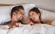 © Chanelle2000/peopleimages.com - Couple, bed and laughing with love, care and commitment together at home with funny joke. Morning, marriage and anniversary with silly, fun and happy people with romance and duvet cover in bedroom