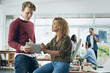 © peopleimages.com - Tablet, business people and conversation with web design for company website layout update with planning. Desk, tech and creative staff with collaboration, work and discussion at coworking office
