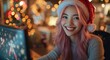 © Imtiaz - Christmassy office. Happy young asian female office worker with pink hair dressed as santa claus working at computer with business team at xmas holiday period. Festive inclusive workplace