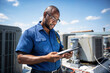 © Александр Марченко - Technician inspecting air conditioning unit on rooftop using tablet