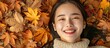 © HN Works - A lovely Asian girl smiles while lying on fall leaves in a peaceful moment captured in a photo with space for text showcasing autumn fashion. Creative banner. Copyspace image