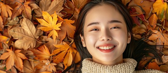 Sticker - A lovely Asian girl smiles while lying on fall leaves in a peaceful moment captured in a photo with space for text showcasing autumn fashion. Creative banner. Copyspace image