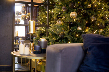 Christmas interior with a beautiful Christmas tree, sofa, light bulbs and dark background.