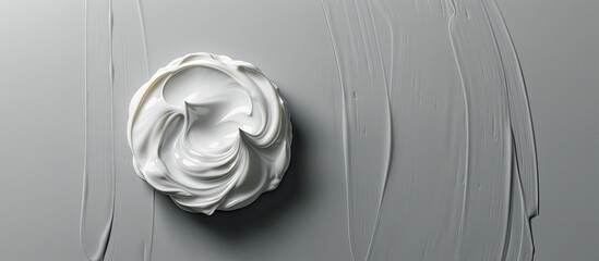 Wall Mural - Top view of face cream on a grey backdrop with copy space image available for text