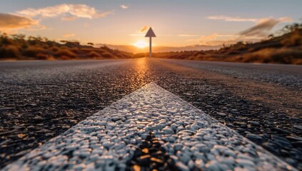 Wall Mural - A straight road with an arrow painted on it, leading towards the horizon at sunset. The asphalt is smooth and clean, reflecting light from above.