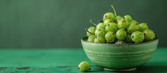 Aufkleber - Fresh gooseberries displayed in a bowl on a green backdrop with copy space image included