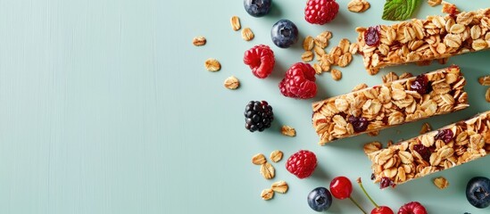 Aufkleber - Top view of delectable homemade granola bars and fresh berries arranged on a pale green surface featuring a banner layout with ample copy space image