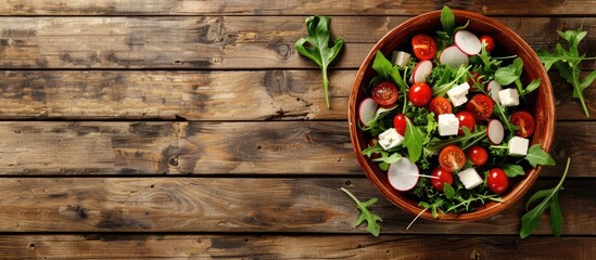 Poster - Fresh vegetable salad with radish and feta cheese in a bowl on a wooden background ideal for copy space image