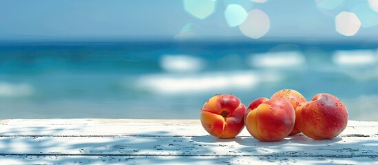 Wall Mural - A serene outdoor setting with nectarines displayed on a white wooden table against a blurred sea background providing ample copy space for food drinks and products