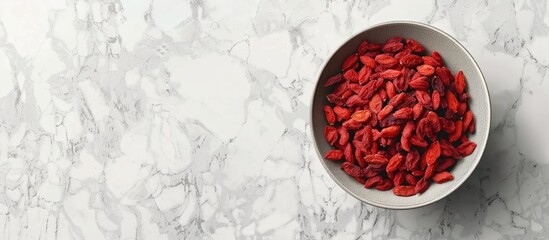 Aufkleber - Top view of a bowl with dried goji berries on a light textured table creating copy space image
