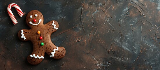 Sticker - A chocolate coated gingerbread man cookie with a cane and colorful icing on a dark background viewed from the top with space for text or image. Creative banner. Copyspace image